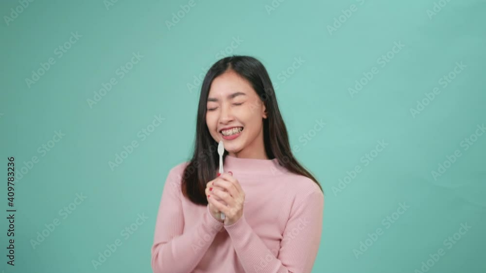 Asian young beautiful woman smile toothbrush instead microphone dancing enjoying music, Female brush teeth singing song have fun isolated on blue background, lifestyle dental hygiene and health. Asian young beautiful woman smile toothbrush instead microphone dancing enjoying music, Female brush teeth singing song have fun isolated on blue background, lifestyle dental hygiene and health.