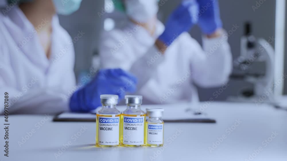 Close-up shot of Coronavirus vaccine set infront of researchers team. Close-up shot of Coronavirus vaccine set infront of researchers team.