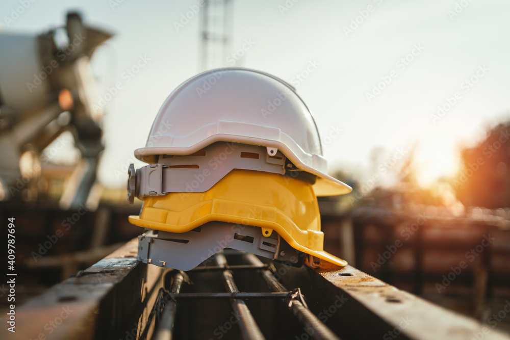 white and yellow helmet on steel in construction site white and yellow helmet on steel in construction site