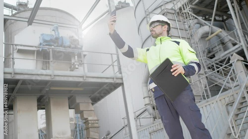 Engineer taking a photo with his mobile phone in a factory. Inspection concept in industry. Selective focus.