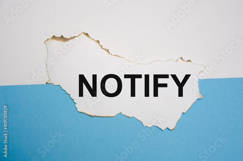 the word notify is written on a white sheet of paper on a white blue-blue background