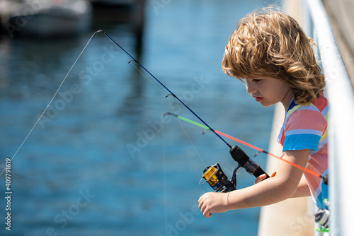 Child fishing on rod. Young fisher. Boy with spinner at river. Fishing concept.