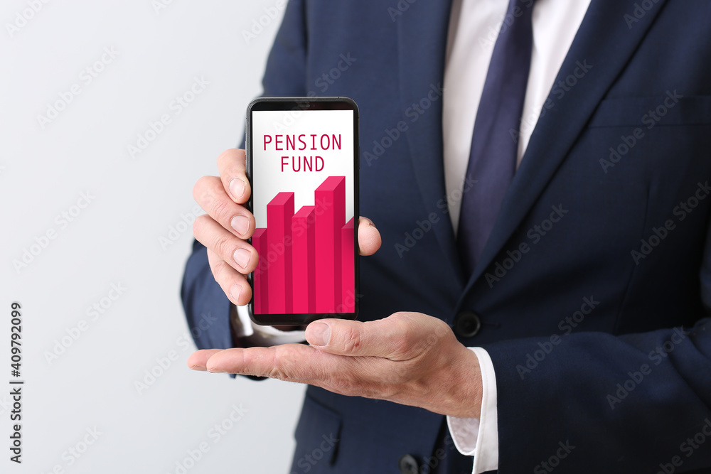 Businessman holding mobile phone with open page of online pension fund on light background Businessman holding mobile phone with open page of online pension fund on light background
