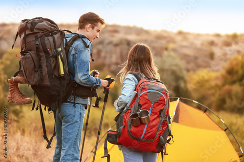 Couple of young tourists near tent in countryside
