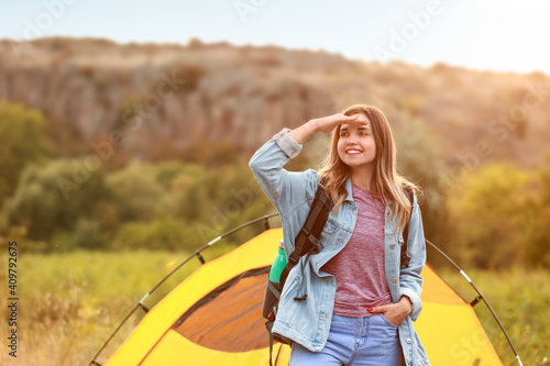 Young female tourist near tent in countryside
