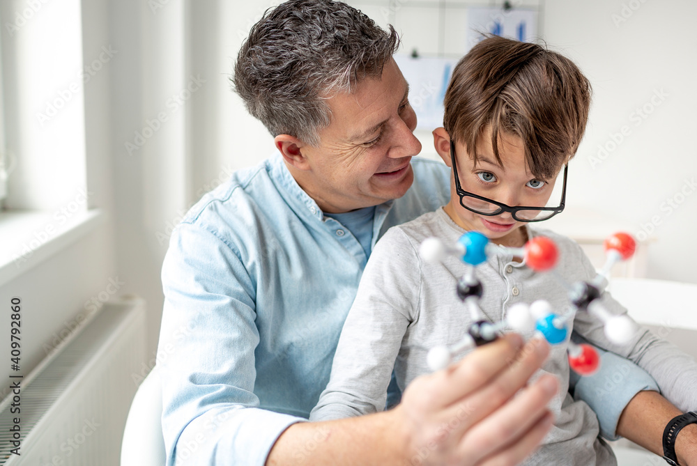 Father and son playing with atoms model, learning chemistry. Father and son playing with atoms model, learning chemistry.