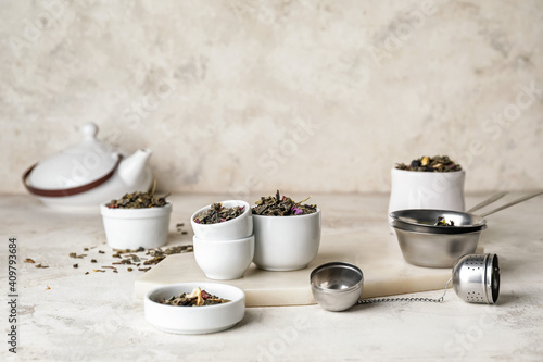Composition with bowls of dry fruit tea on light background