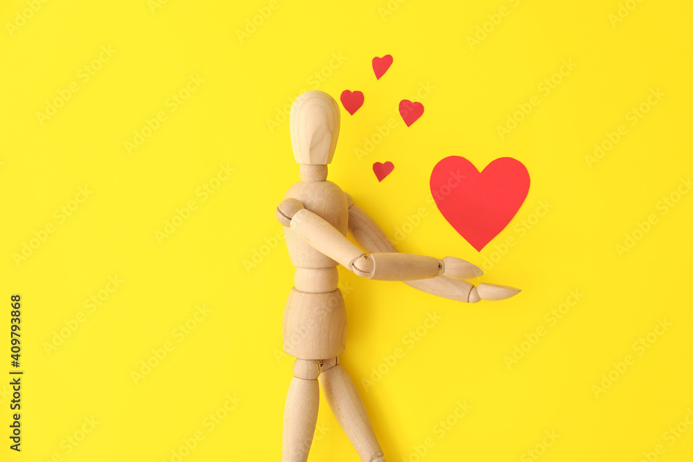 Wooden mannequin with hearts on color background Wooden mannequin with hearts on color background