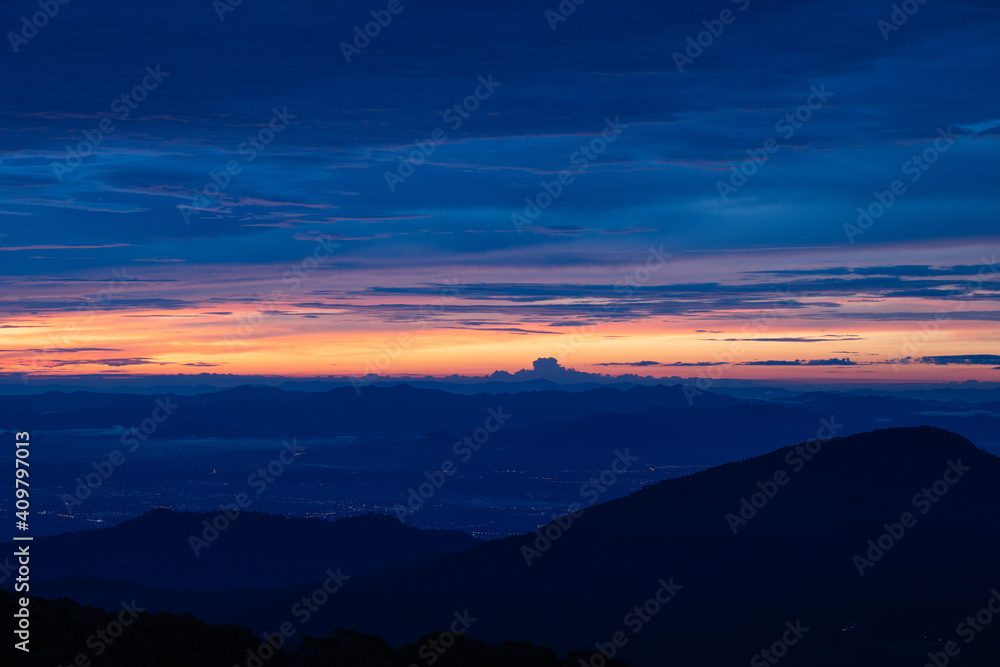 the twilight sky with orange and blue and city light from mountain view