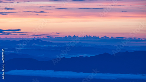 the twilight sky with orange and blue and city light from mountain view © nat693