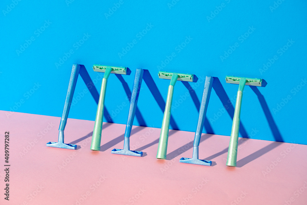 Disposable razor on blue and pink background Disposable razor on blue and pink background