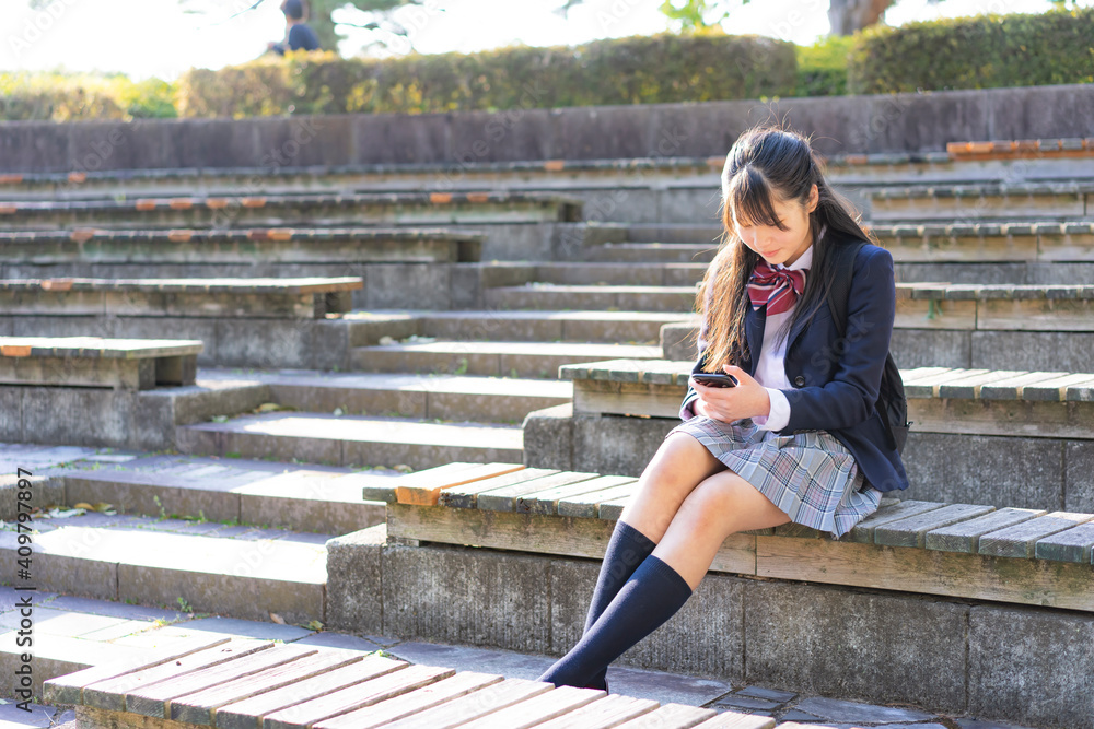 スマートフォンを見る女子学生 スマートフォンを見る女子学生