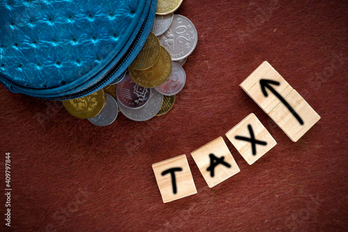 Concept image of increase TAX with props coins over brown textured background