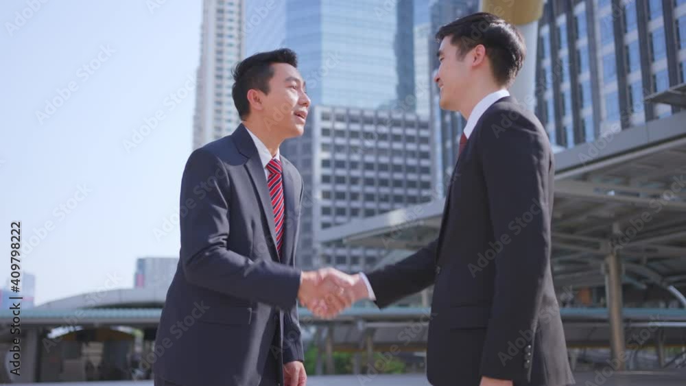 Asian businessmen making handshake in the city, cityscape background. Asian businessmen making handshake in the city, cityscape background.