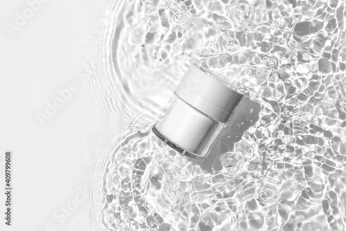 Obraz White cosmetic jar on the water surface. Blank label for branding mock-up. Summer water pool fresh concept. Flat lay, top view.