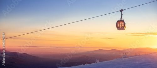 Colorful winter sunset lift ski resort in Sheregesh mountains with clouds forest Russia