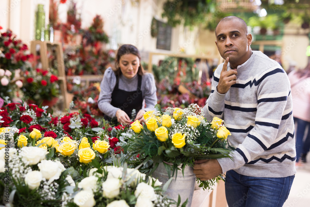 Portrait of man chooses flowers in flower shop