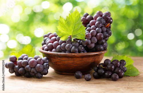 fresh ripe grapes with leaves in a bowl