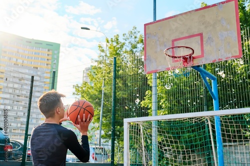 Teenage guy playing street basketball. Active lifestyle of teenagers