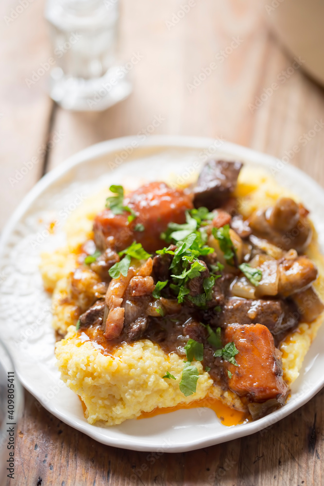 Boeuf bourguignon with carrots, mushrooms, topped with parsley served with polenta Boeuf bourguignon with carrots, mushrooms, topped with parsley served with polenta