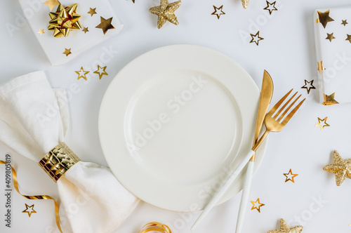 Christmas and New Year holiday celebration table setting on white background with golden decorations. Top view. Flat lay photo