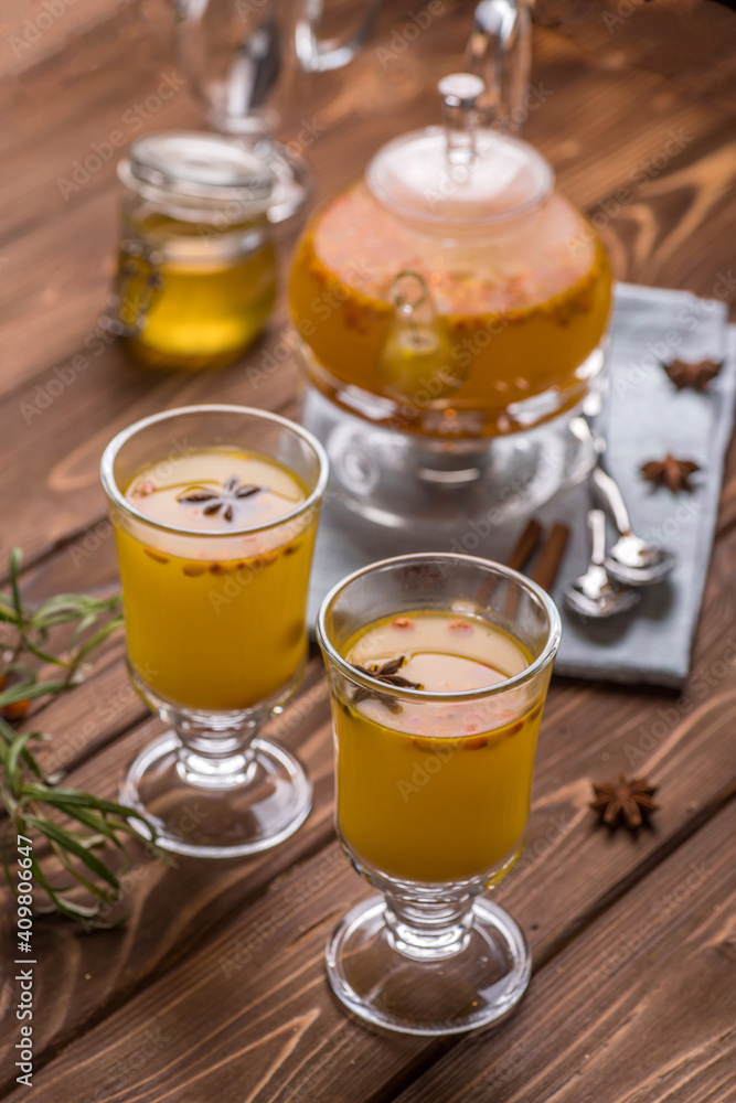 Beautiful glass teapot with orange sea buckthorn tea. Hot winter drinks, Beautiful glass teapot with orange sea buckthorn tea. Hot winter drinks,