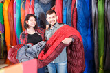 Loving couple is buying a sleeping bag in a sports store
