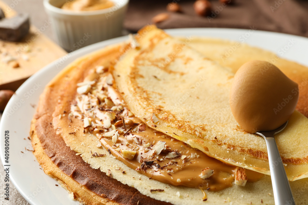 Plate of crepes with peanut butter and nuts, close up Plate of crepes with peanut butter and nuts, close up