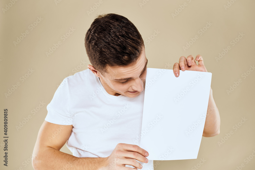 man in white t-shirt sheet of paper in hands Copy Space cropped view beige background man in white t-shirt sheet of paper in hands Copy Space cropped view beige background