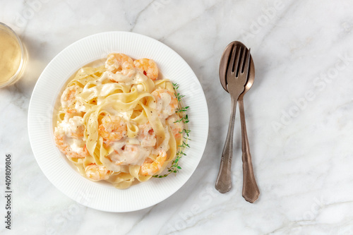 Pappardelle pasta with shrimps and cream sauce, shot from the top with a place for text