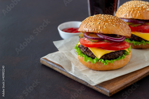 Burgers with cutlet, tomato, lettuce, cucumber, onion and cheese. American cuisine. Fast food. Cheeseburger.