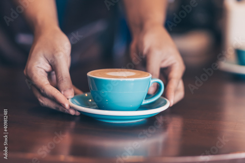 Barista serving a coffee to customer at the coffee shop.