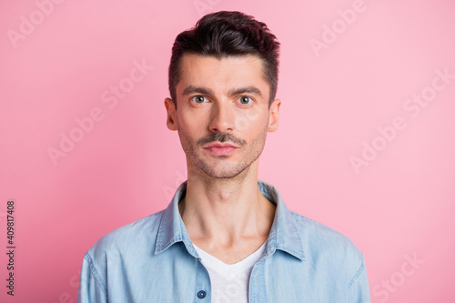 Photo of serious brown haired young handsome man wear blue shirt isolated on pastel pink color background