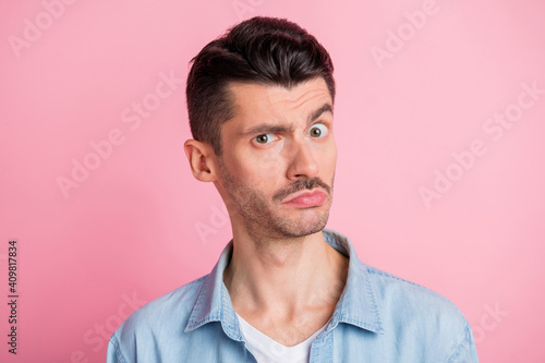 Photo portrait of uncertain man doubtful suspicious wearing casual clothes isolated pastel pink color background