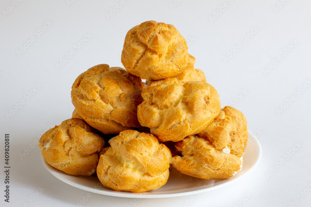 Eclairs on white plate on a whight background. eclairs with cream. Eclairs on white plate on a whight background. eclairs with cream.
