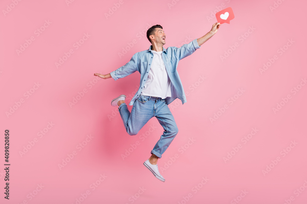 Full body photo of cheerful happy man catch like icon jump up air isolated on pastel pink color background Full body photo of cheerful happy man catch like icon jump up air isolated on pastel pink color background