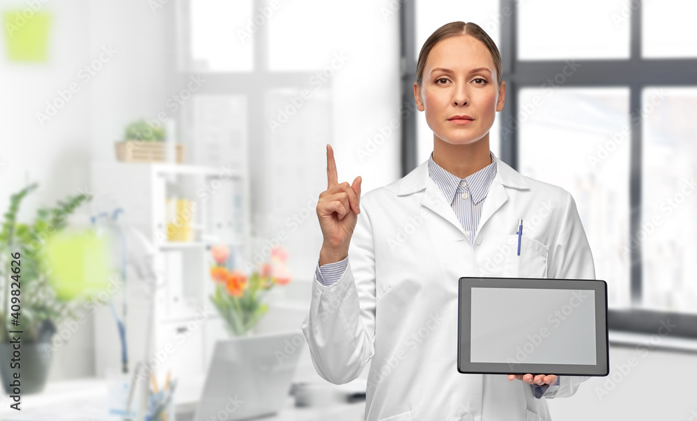 medicine, profession and healthcare concept - female doctor in white coat with tablet pc computer pointing finger up over medical office at hospital on background medicine, profession and healthcare concept - female doctor in white coat with tablet pc computer pointing finger up over medical office at hospital on background