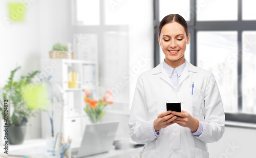 Wallpaper Mural medicine, profession and healthcare concept - happy smiling female doctor with stethoscope using smartphone over medical office at hospital on background Torontodigital.ca