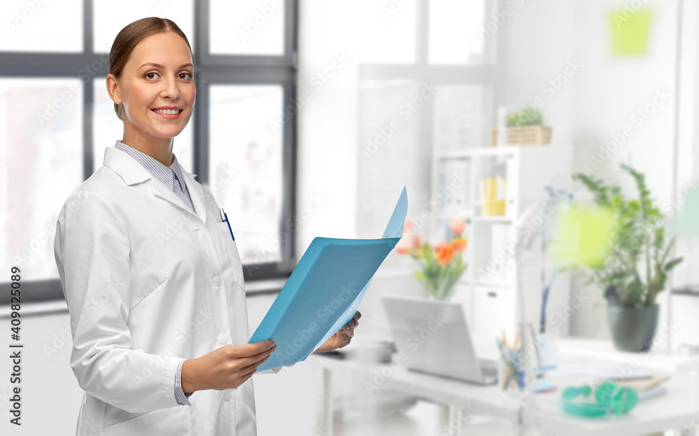 Obraz premium medicine, science and healthcare concept - happy smiling female doctor in white coat with folder over medical office at hospital on background