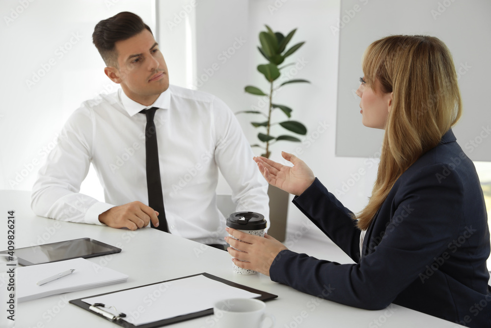 Office employees talking at table during meeting Office employees talking at table during meeting