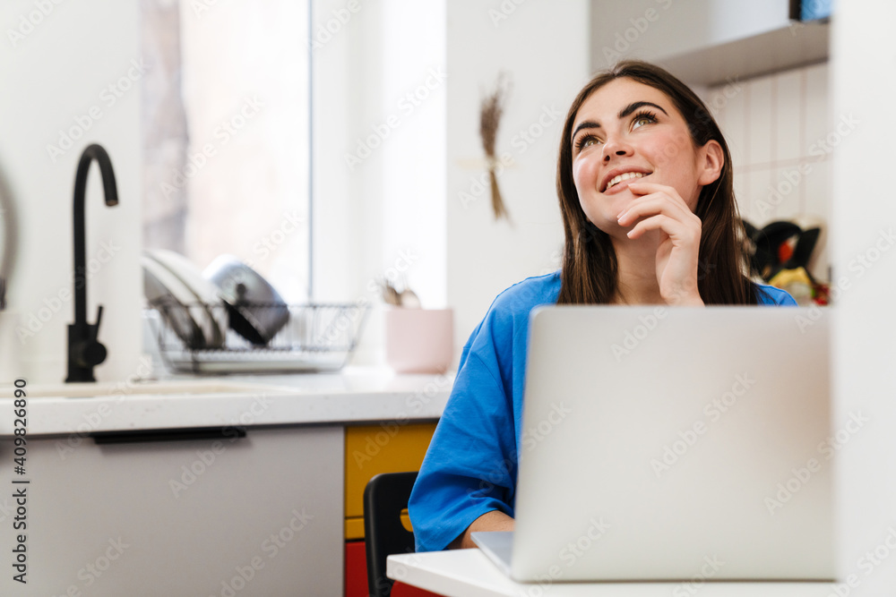 Lovely smiling young woman working on laptop computer Lovely smiling young woman working on laptop computer
