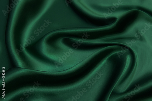 Texture, background, pattern. Texture of green silk fabric. Beautiful emerald green soft silk fabric. photo