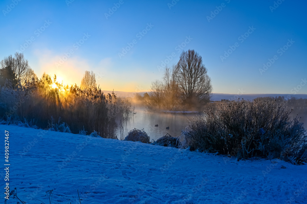 sunrise and mist over small pond i Kumla lakepark Sweden