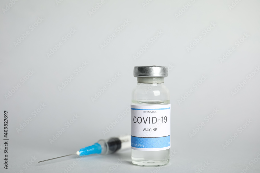 Vial with coronavirus vaccine and syringe on light background Vial with coronavirus vaccine and syringe on light background
