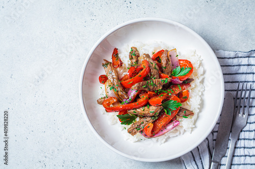 Photos Fried pieces of beef with vegetables and rice in white plate