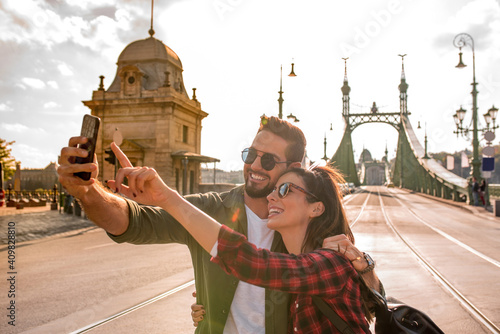 A traveling couple taking a selfie in Budapest