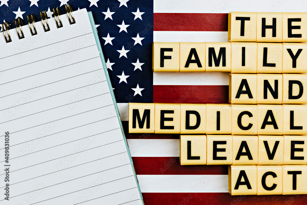 topview photo on FMLA (the family medical leave act) theme. photo of open notepad with blank space, on a background of United States flag topview photo on FMLA (the family medical leave act) theme. photo of open notepad with blank space, on a background of United States flag