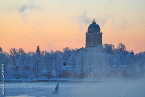 Suomenlinna fortress island on  cold winter morning at sunrise with sea fog and icy Baltic sea. 