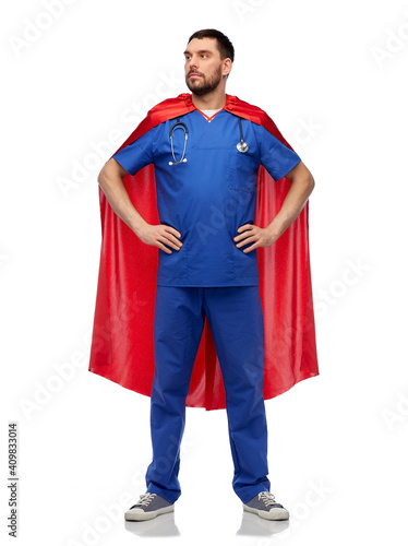 healthcare, profession and medicine concept - happy smiling doctor or male nurse in blue uniform and red superhero cape with stethoscope over white background