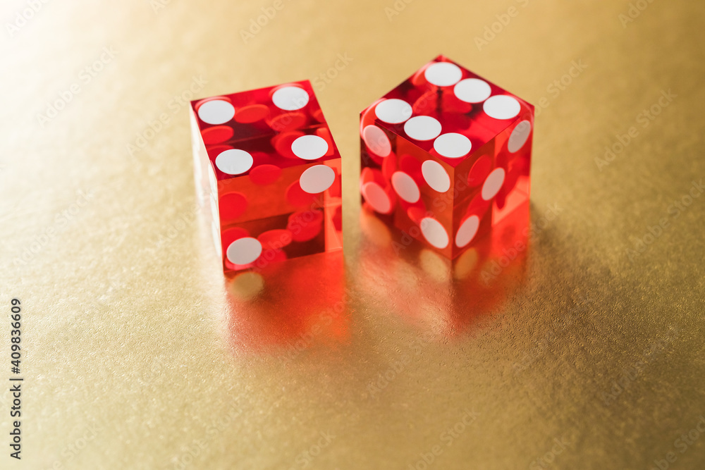 Two red glass dice on a golden background. The result is four and six. Two red glass dice on a golden background. The result is four and six.
